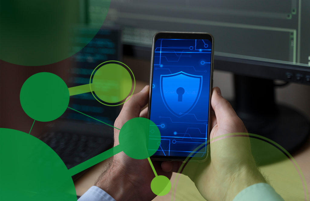 A man's hands hold a phone with a picture of a blue shield on the screen